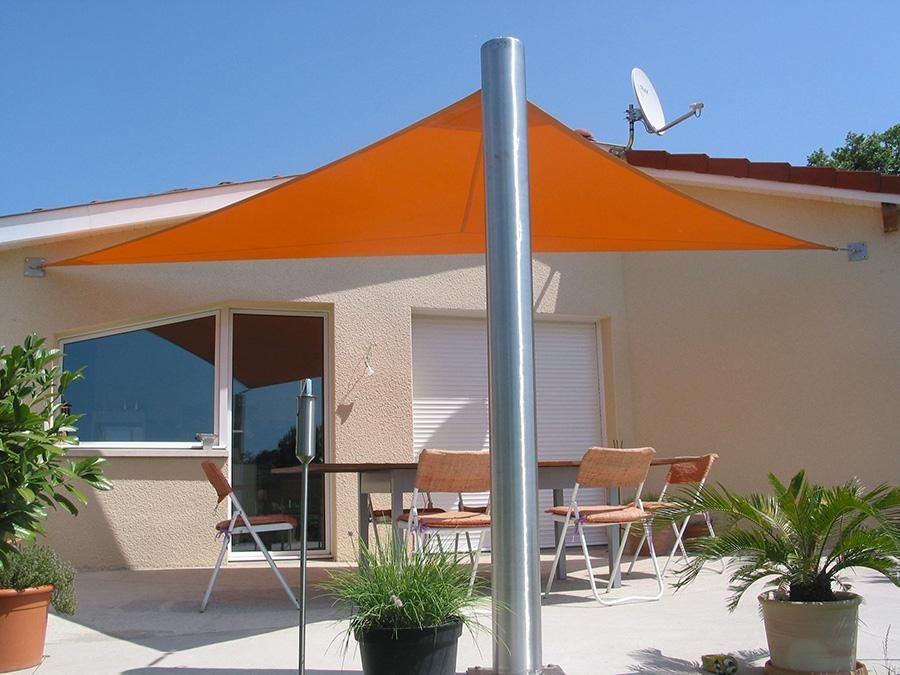 voile d'ombrage triangle fixée sur un poteau et au mur
