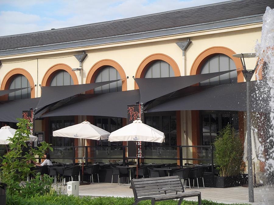 voiles d'ombrage triangulaires sur une terrasse de café